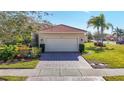 Home features a two-car garage and a well-manicured lawn at 4935 Marble Springs Cir, Wimauma, FL 33598