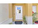 White front door entry with plants and a stone mat at 614 105Th N Ln, St Petersburg, FL 33716