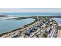 An aerial view showcasing the condo building's location near the water and a road at 7 Elgin Pl # 701, Dunedin, FL 34698