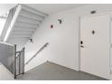 White walls, gray railing, and a white door in a condo building stairwell at 7 Elgin Pl # 701, Dunedin, FL 34698