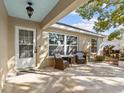 Relaxing outdoor patio with comfortable seating, tiled floor, and a view of the landscaped yard at 807 Cavemill Way, Tarpon Springs, FL 34689