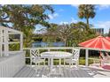 White deck overlooking a pond with seating for relaxing at 1 Gallinule Pl, Belleair, FL 33756