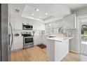 Modern white kitchen with stainless steel appliances and a quartz countertop at 1 Gallinule Pl, Belleair, FL 33756