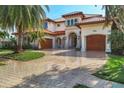 Beautiful Mediterranean-style home with a paver driveway, lush landscaping, and grand entrance at 1097 Eden Isle Ne Dr, St Petersburg, FL 33704