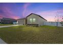 One-story home with a two-car garage, stone accents, and a sunset backdrop at 1418 Bluejack Oak Dr, Seffner, FL 33584