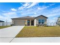 Tan house with a two-car garage and a neatly manicured lawn at 1418 Bluejack Oak Dr, Seffner, FL 33584