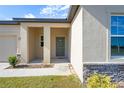 Front entrance with a covered porch, double columns, and stone accents at 1418 Bluejack Oak Dr, Seffner, FL 33584