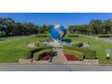 Community entrance with a large globe fountain and landscaping at 2363 Israeli Dr # 61, Clearwater, FL 33763