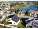 Aerial view showcasing a community with houses, golf course, and lake at 24165 Buckingham Way, Punta Gorda, FL 33980