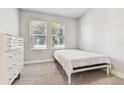 Minimalist bedroom with a simple bed frame, white dresser, and natural light at 2511 N Grady Ave # 23, Tampa, FL 33607