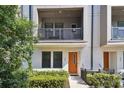 Townhome exterior featuring an orange front door, balcony, and walkway at 2511 N Grady Ave # 23, Tampa, FL 33607