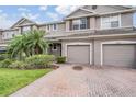 Two-story townhome with two-car garage and landscaped front yard at 26914 Juniper Bay Dr, Wesley Chapel, FL 33544