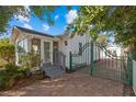 Exterior view of a quaint home with a screened porch, garden gate, and brick driveway at 2907 Clinton S St, Gulfport, FL 33707