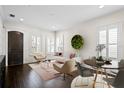 Bright living room features dark hardwood floors, neutral furniture, modern lighting, and access to dining area at 3107 W Palmira Ave, Tampa, FL 33629