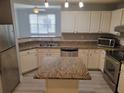 Well-lit kitchen with white cabinets, granite countertops, stainless steel appliances, and a center island at 501 Knights Run Ave # 1113, Tampa, FL 33602