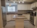 Bright kitchen features granite counters, stainless appliances, and a center island at 501 Knights Run Ave # 1113, Tampa, FL 33602