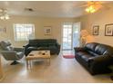 Living room with two black leather sofas, a coffee table, and a recliner at 6103 Elmhurst Dr, New Port Richey, FL 34653