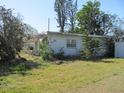 Side view of a small white single-story house needing repairs and yard work at 6701 Hibiscus S Ave, South Pasadena, FL 33707