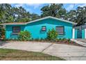 Teal house exterior with well-maintained landscaping at 717 Carolina Ave, Tarpon Springs, FL 34689