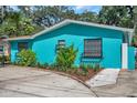 Side view of teal house showcasing landscaping at 717 Carolina Ave, Tarpon Springs, FL 34689