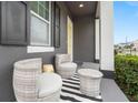 Front porch with wicker chairs and striped rug at 7602 S Desoto St, Tampa, FL 33616