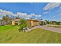 Exterior view of a single-story house with a palm tree and well-manicured lawn at 1123 Emerald Dunes Dr, Sun City Center, FL 33573