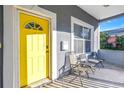 Gray house with yellow door, white trim, and two chairs on the porch at 1410 Prescott S St, St Petersburg, FL 33712