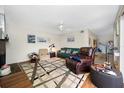 Living room features green couch, comfy chairs, and wood floors at 14525 Catalina Cir, Seminole, FL 33776