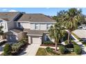 Aerial view of a community with houses, palm trees, and a lake at 14935 Skip Jack Loop # 106, Lakewood Ranch, FL 34202