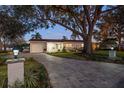 Updated home exterior at night, showcasing landscaping and a paved driveway at 1690 74Th N Ave, St Petersburg, FL 33702