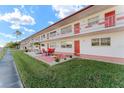 Front view of a condo building with red accents and a grassy area at 1950 58Th N Ave # 9, St Petersburg, FL 33714