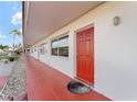 Side view of a condo building showcasing red doors and a red tiled walkway at 1950 58Th N Ave # 9, St Petersburg, FL 33714