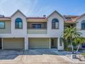 Two-story condo building with attached garages and palm trees at 2372 Hanover Dr, Dunedin, FL 34698