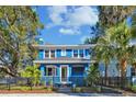 Two-story blue house with a white trim, black fence, and palm trees at 2751 2Nd S Ave, St Petersburg, FL 33712