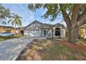 One-story house with a two-car garage and mature tree in front at 305 Crayford Pl, Valrico, FL 33594