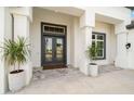 Gray double front doors with sidelights and planters at 3571 Recurve Cir, Sarasota, FL 34240