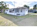 White single-wide mobile home with carport and landscaped lawn at 37418 Hammond Dr, Zephyrhills, FL 33541