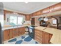 Galley kitchen with wood cabinets, double sink, and view into bedroom at 4001 Keene Rd, Plant City, FL 33565