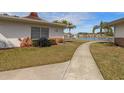 Back exterior view of home showcasing a walkway and pond views at 4316 Tahitian Gardens Cir # H, Holiday, FL 34691