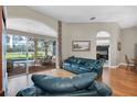 Living room with hardwood floors, access to the lanai, pool, and kitchen at 4996 Felecity Way, Palm Harbor, FL 34685