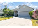 Tan house with two car garage and manicured landscaping at 5004 Brickell Park Cv, Bradenton, FL 34211