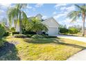 House with palm trees, lush landscaping, and a two-car garage at 5004 Brickell Park Cv, Bradenton, FL 34211