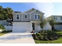 Two-story home with gray siding, landscaping, and a two-car garage at 507 N Bradford Ave, Tampa, FL 33609