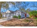 Newly painted light gray house with a red front door and well-maintained lawn at 5605 Tanagergrove Way, Lithia, FL 33547