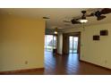 Open living room showcasing neutral walls, tile flooring, multiple ceiling fans, and natural light throughout at 1322 Kenmore St, Port Charlotte, FL 33952