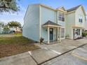 Side view of a light blue two-story townhome with a small porch at 13817 Stone Mill Way, Tampa, FL 33613