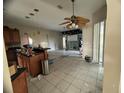 Kitchen with wood cabinets, an island, and a view of the living room at 1530 Davenport Dr, New Port Richey, FL 34655