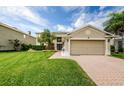 Tan two-story house with a large lawn and attached garage at 1553 Regal Mist Loop, Trinity, FL 34655