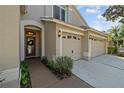 Home featuring a welcoming front entrance and a three-car garage at 15555 Martinmeadow Dr, Lithia, FL 33547