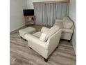 Living room featuring light beige upholstered furniture and wood-look flooring at 19505 Quesada Ave # O105, Port Charlotte, FL 33948